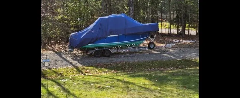 Slide: The Image of 2006 Polar Kraft Sportsman Series 27 boat covered and parked outdoors. - 3