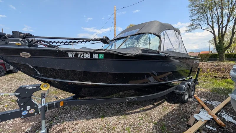The Image of 2024 Lund Fisherman 2075 on trailer, black design, parked outdoors. - 1