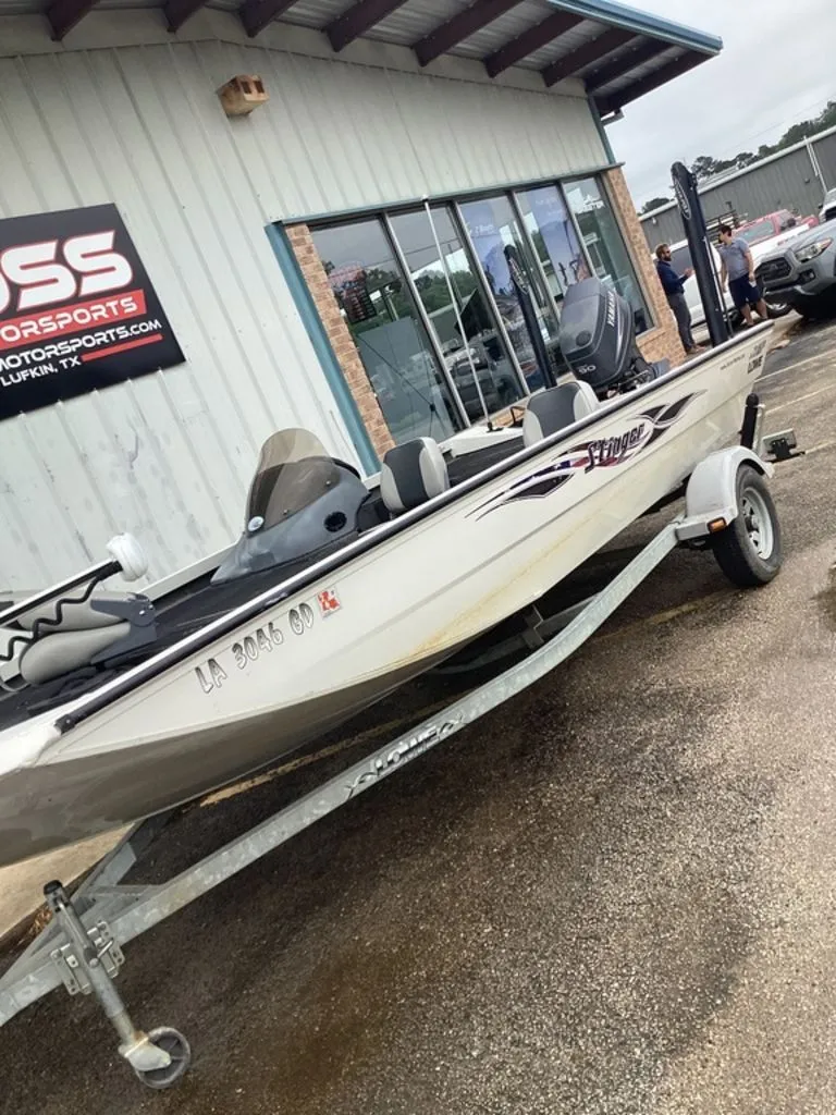 Slide: The Image of 2013 Lowe Stinger 18 HP boat on trailer outside store. - 13