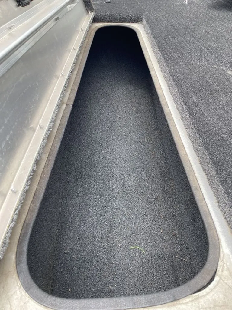 Slide: The Image of Lowe Stinger 18 HP 2013 boat storage compartment with carpeted interior. - 36