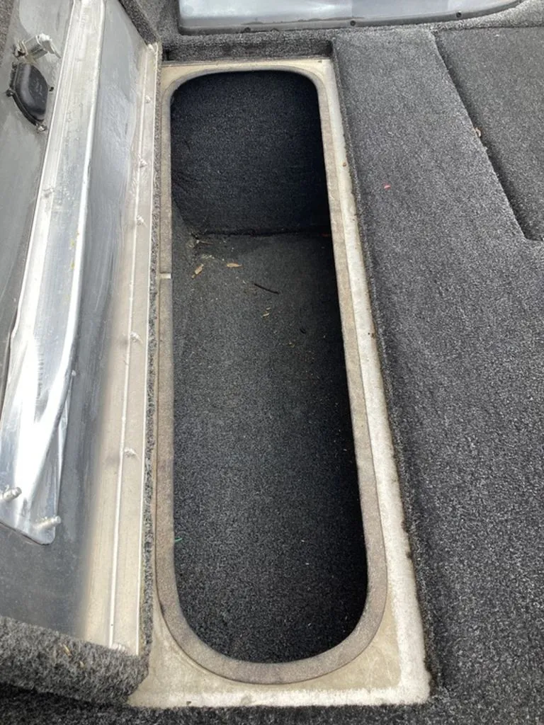 Slide: The Image of Lowe Stinger 18 HP 2013 boat storage compartment with carpeted interior. - 43