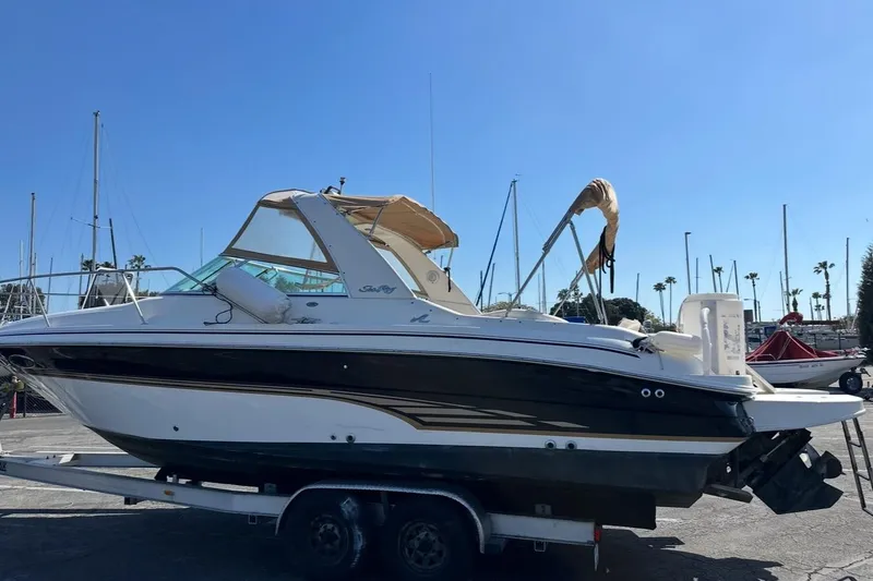 The Image of 2001 Sea Ray 280 boat on trailer at marina, clear blue sky background. - 0