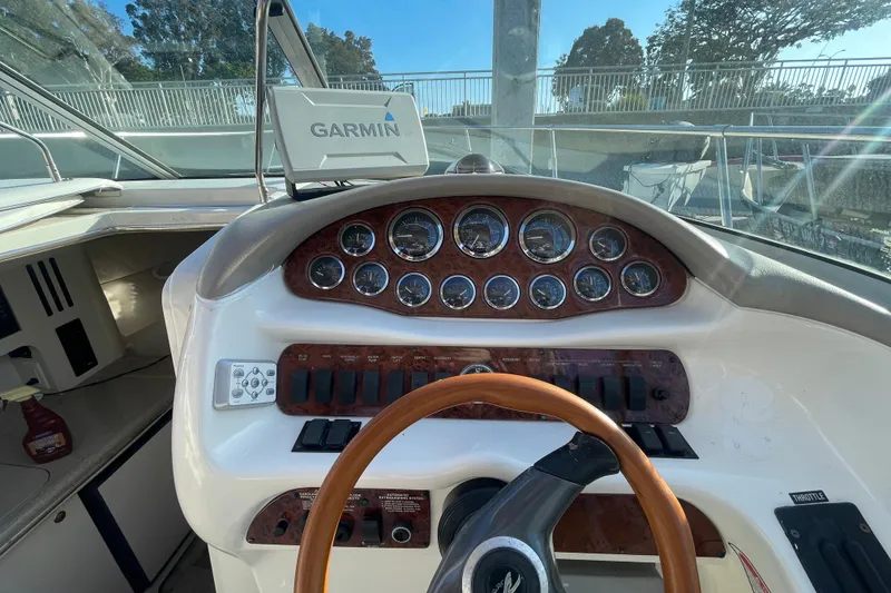 Slide: The Image of 2001 Sea Ray 280 boat dashboard with Garmin navigation system and wooden steering wheel. - 12