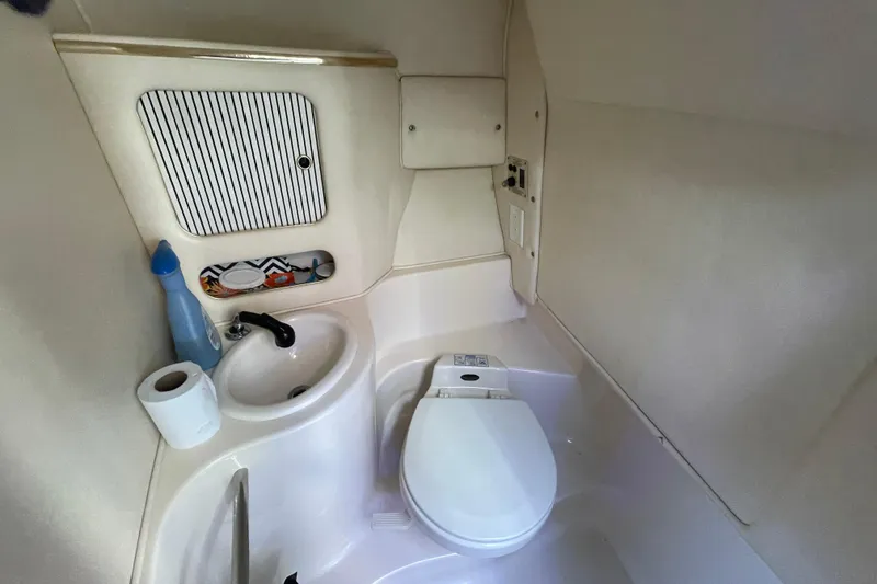 Slide: The Image of 2001 Sea Ray 280 boat bathroom with sink, toilet, and storage compartment. - 17