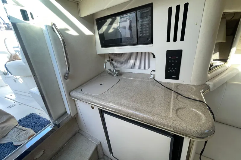 Slide: The Image of Compact kitchen area in a 2001 Sea Ray 280 boat with sink and microwave. - 18