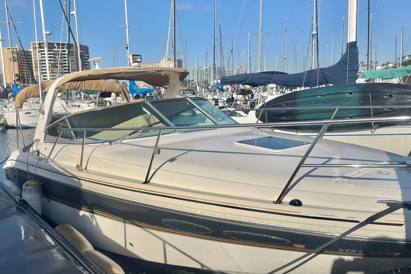 Slide: The Image of 2001 Sea Ray 280 boat docked in a marina, surrounded by other sailboats. - 2