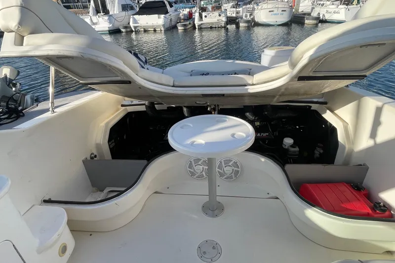 Slide: The Image of 2001 Sea Ray 280 boat interior with open engine compartment and seating area at marina. - 20