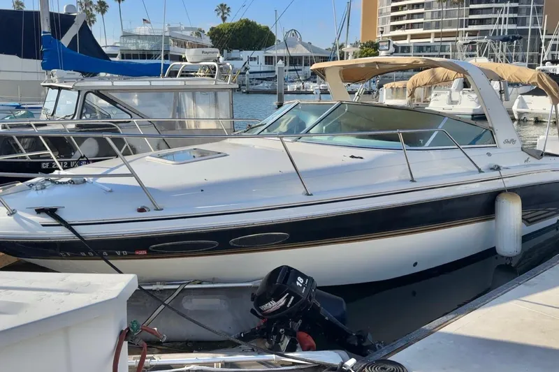 Slide: The Image of 2001 Sea Ray 280 boat docked at a marina with surrounding yachts. - 3