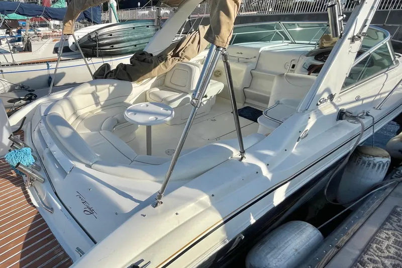 Slide: The Image of 2001 Sea Ray 280 boat with spacious seating and sleek design at a marina. - 4