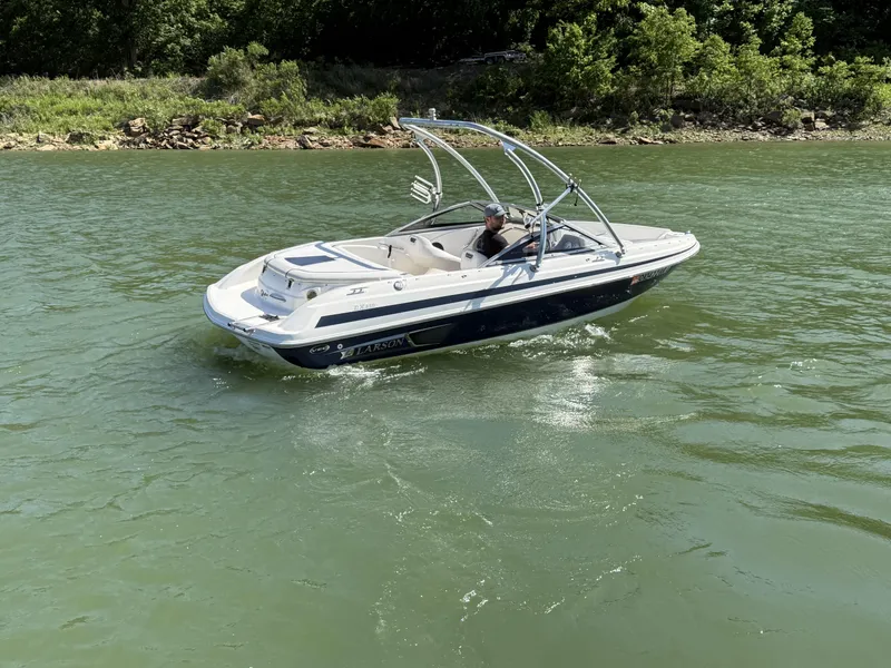 Slide: The Image of 2011 Larson LX850 boat cruising on a calm lake. - 11