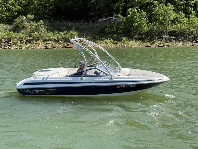 Slide: The Image of 2011 Larson LX850 boat cruising on a lake. - 12
