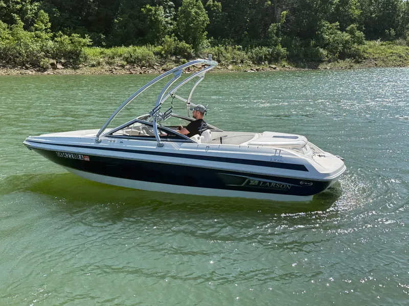 Slide: The Image of 2011 Larson LX850 boat cruising on a serene lake. - 22