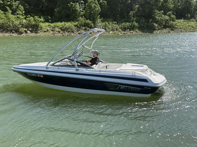 Slide: The Image of 2011 Larson LX850 boat cruising on a serene lake. - 9