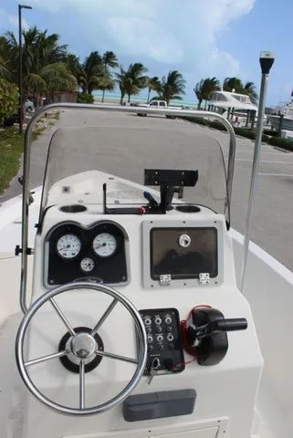 Slide: The Image of 2016 NauticStar 1810 boat console with palm trees in background. - 12