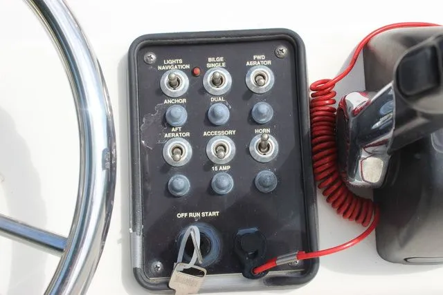 Slide: The Image of 2016 NauticStar 1810 control panel with switches and ignition key. - 14
