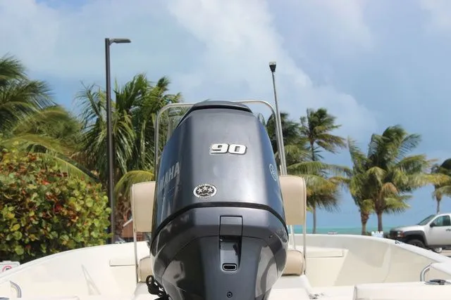 Slide: The Image of 2016 NauticStar 1810 boat with Yamaha 90 engine, palm trees in background. - 7