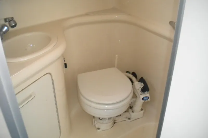 Slide: The Image of Compact bathroom in 1996 Sea Ray 270 Sundancer boat with toilet and sink. - 18