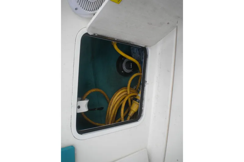 Slide: The Image of Storage compartment on a 1996 Sea Ray 270 Sundancer with yellow power cables. - 19