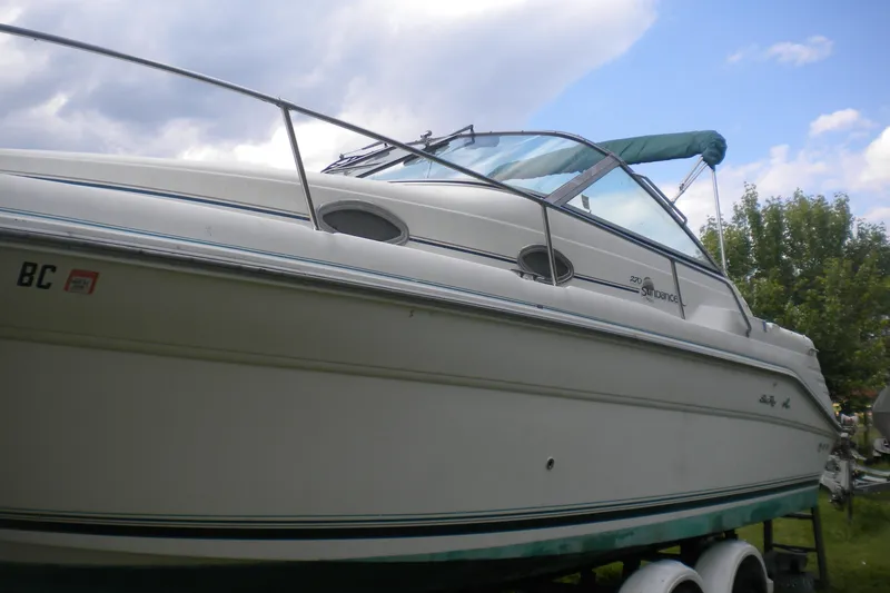Slide: The Image of 1996 Sea Ray 270 Sundancer boat on trailer under cloudy sky. - 2