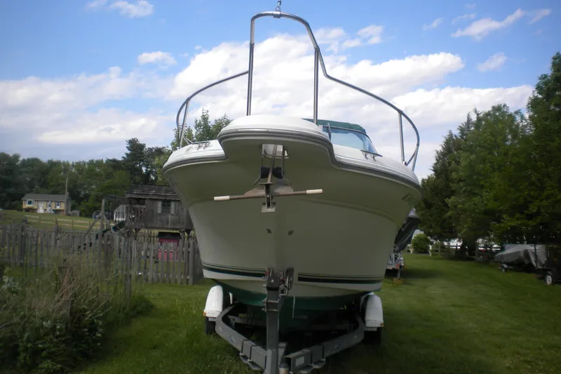 Slide: The Image of 1996 Sea Ray 270 Sundancer boat on trailer, parked on grassy lawn under blue sky. - 3