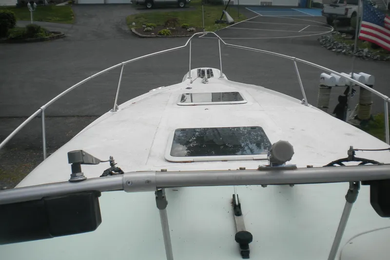 Slide: The Image of 1996 Sea Ray 270 Sundancer boat deck with railing and hatches, parked in driveway. - 7
