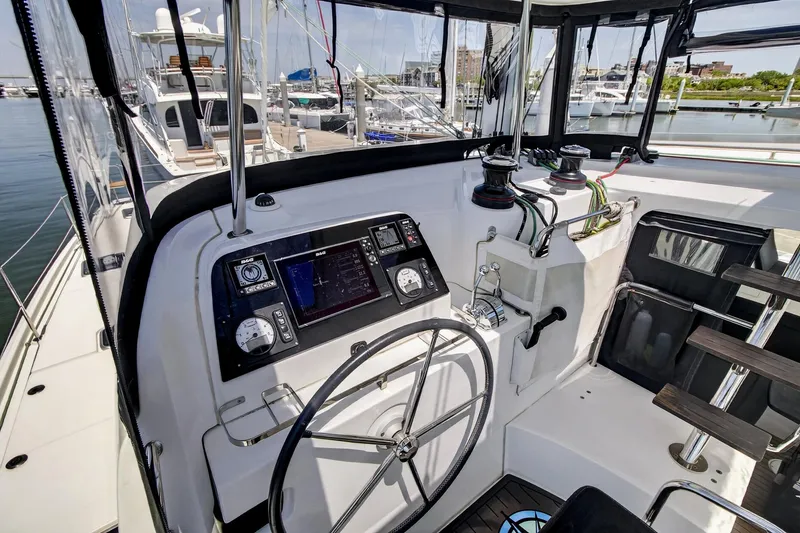 Slide: The Image of Helm station of 2018 Lagoon 42 catamaran with navigation equipment and steering wheel. - 13