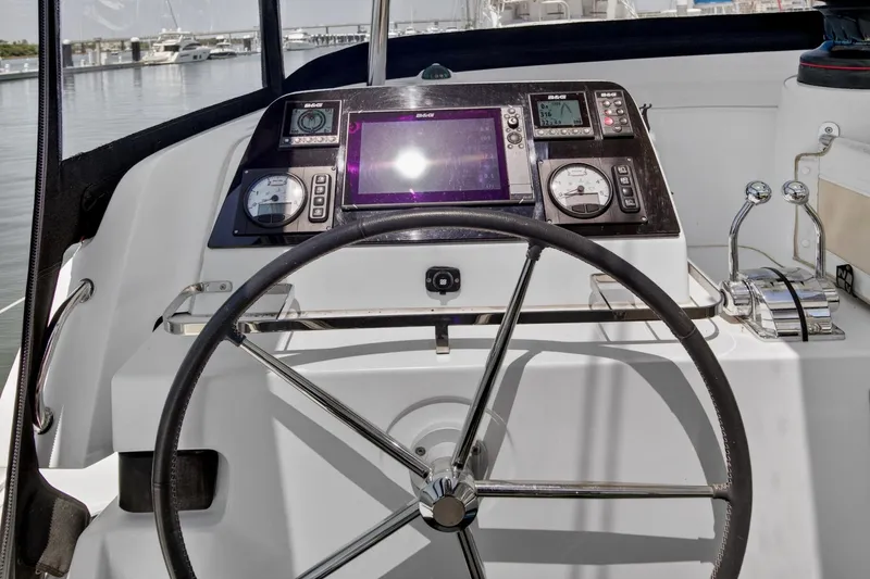 Slide: The Image of Steering wheel and control panel of a 2018 Lagoon 42 catamaran at a marina. - 14