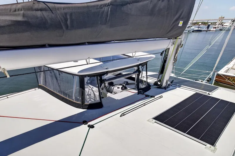 Slide: The Image of 2018 Lagoon 42 catamaran deck with solar panels and covered cockpit, docked at marina. - 16