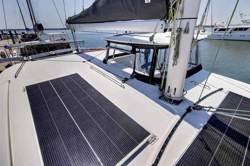 Slide: The Image of 2018 Lagoon 42 catamaran with solar panels on deck, docked at marina. - 18