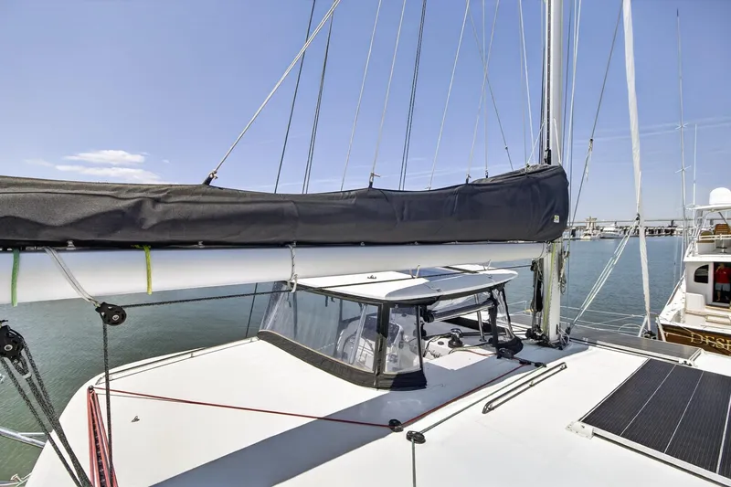Slide: The Image of 2018 Lagoon 42 catamaran with sails furled, docked in a marina under clear skies. - 21