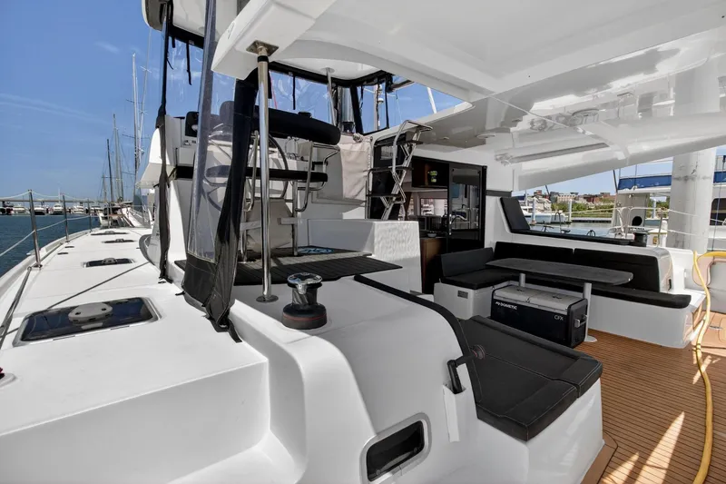 Slide: The Image of Luxurious 2018 Lagoon 42 catamaran deck with seating area and helm station. - 23