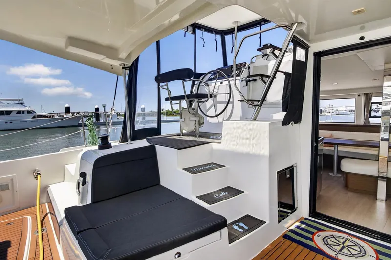 Slide: The Image of Luxurious 2018 Lagoon 42 catamaran interior with helm, seating, and marina view. - 24