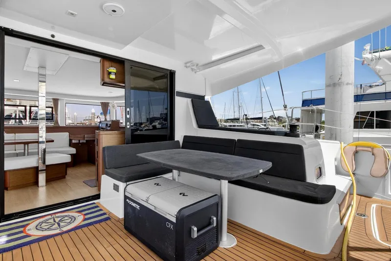 Slide: The Image of 2018 Lagoon 42 catamaran interior with seating area, table, and marina view. - 26