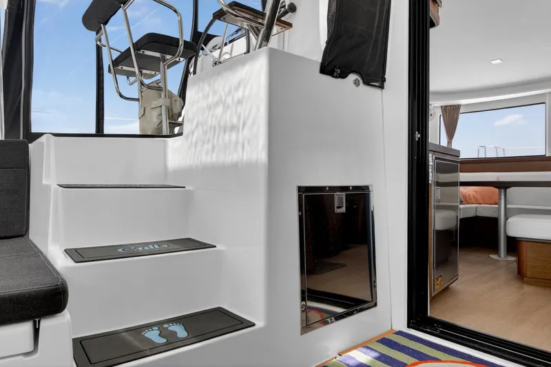 Slide: The Image of Interior view of a 2018 Lagoon 42 catamaran, featuring stairs and a cozy seating area. - 28