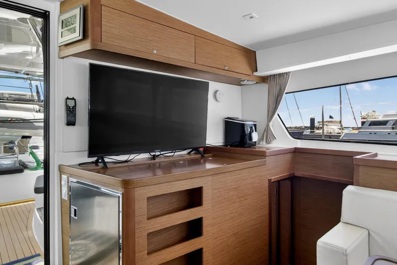 Slide: The Image of Interior of 2018 Lagoon 42 yacht with TV, wooden cabinetry, and marina view. - 31