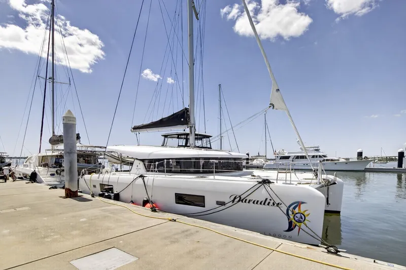 Slide: The Image of 2018 Lagoon 42 catamaran docked at marina under clear blue sky. - 4