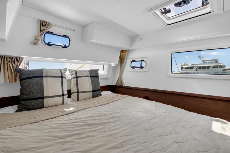 Slide: The Image of Interior cabin of 2018 Lagoon 42 catamaran with cozy bedding and nautical views. - 48