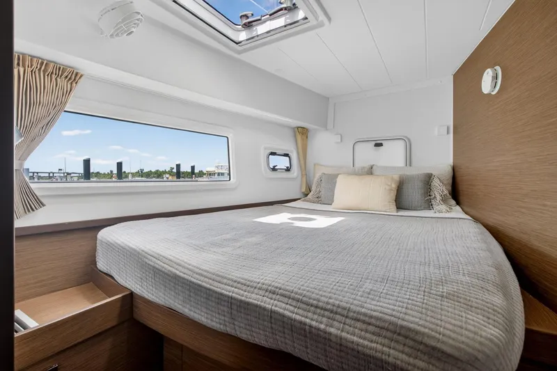 Slide: The Image of Luxurious cabin interior of 2018 Lagoon 42 catamaran with cozy bed and scenic window view. - 52