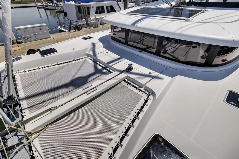 Slide: The Image of 2018 Lagoon 42 catamaran deck with netting and sleek design at marina. - 9