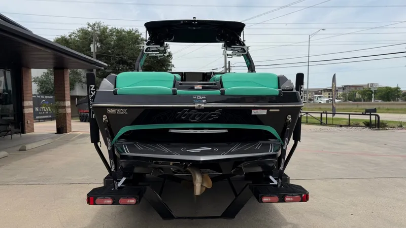 Slide: The Image of Rear view of a 2022 Tigé 23ZX boat on a parking lot. - 4