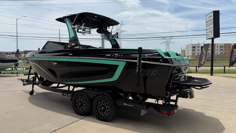Slide: The Image of 2022 Tigé 23ZX boat on trailer, black and green, side view. - 5