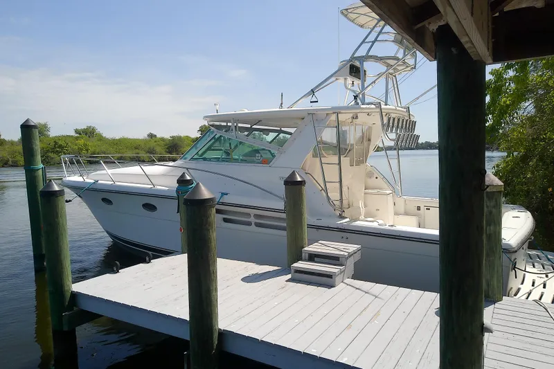 Slide: The Image of 2000 Tiara Yachts 4100 Open docked by a wooden pier on a sunny day. - 11