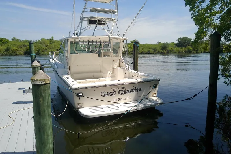 Slide: The Image of 2000 Tiara Yachts 4100 Open docked by a serene riverbank. - 12