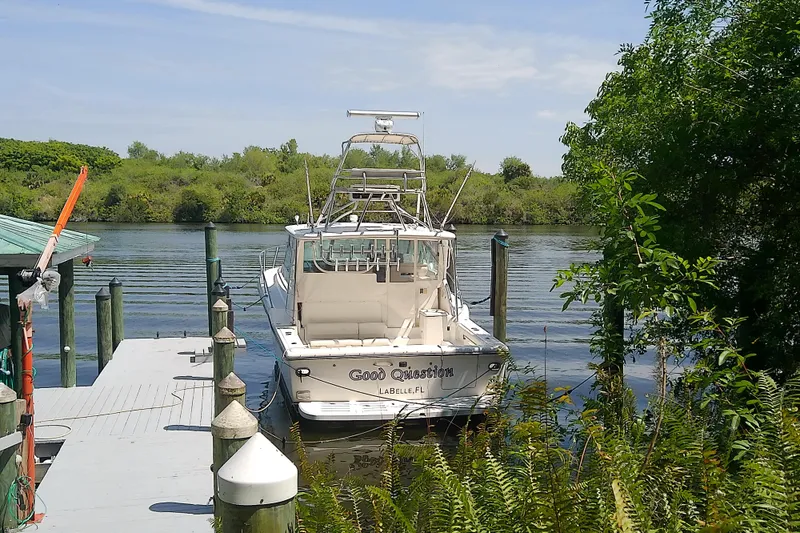 Slide: The Image of 2000 Tiara Yachts 4100 Open docked by lush greenery and calm waters. - 13