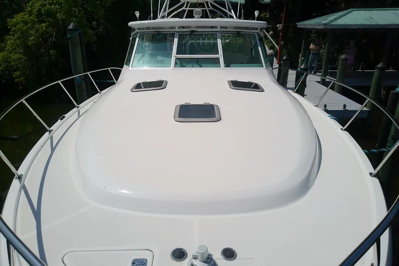 Slide: The Image of 2000 Tiara Yachts 4100 Open boat docked, showcasing sleek deck design and windows. - 15