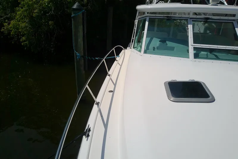 Slide: The Image of 2000 Tiara Yachts 4100 Open boat docked, showcasing sleek deck and windshield design. - 18