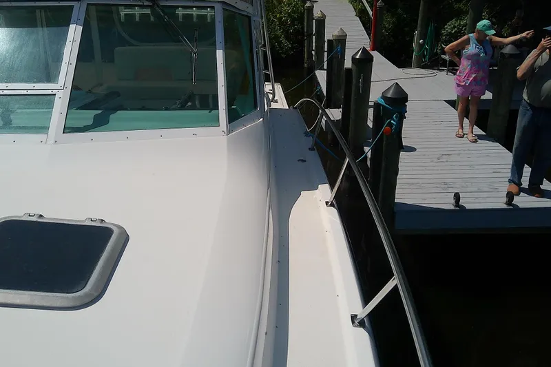 Slide: The Image of 2000 Tiara Yachts 4100 Open docked, with people standing on the pier. - 19