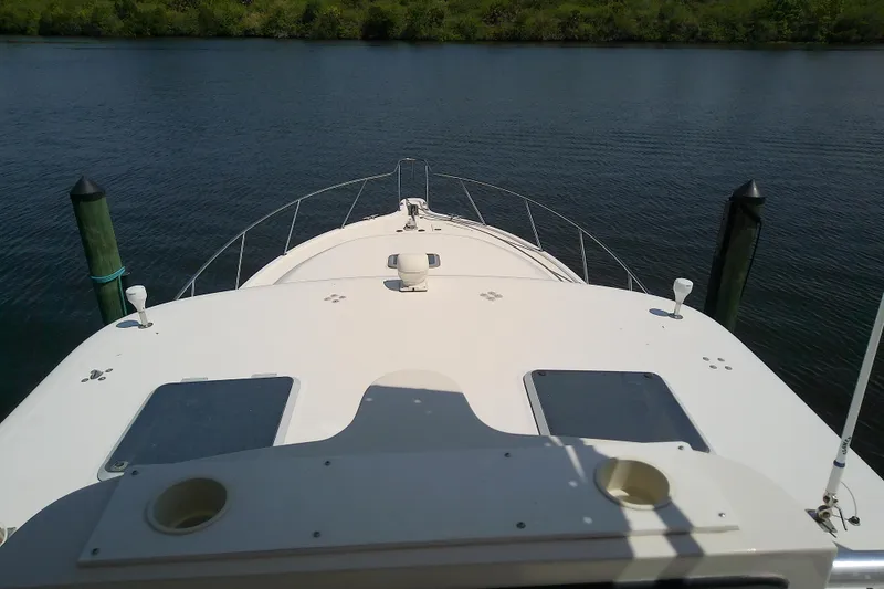 Slide: The Image of Bow view of a 2000 Tiara Yachts 4100 Open on calm water. - 21