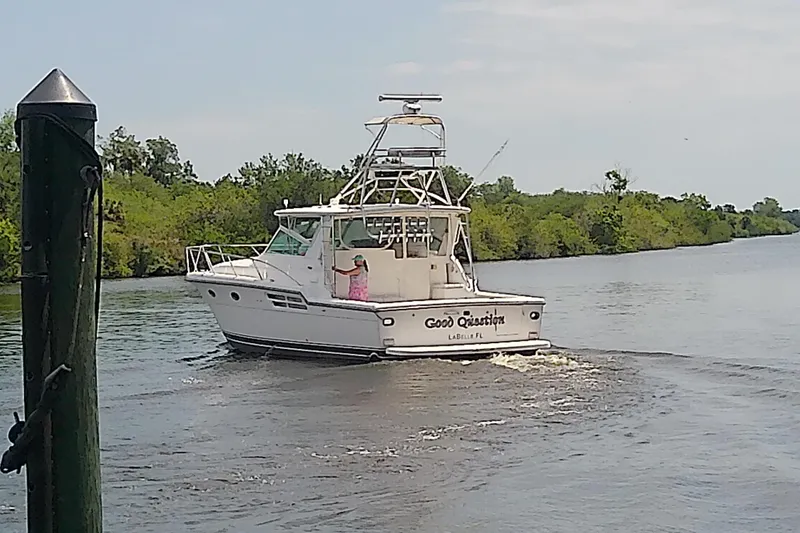 Slide: The Image of 2000 Tiara Yachts 4100 Open cruising on a scenic river near lush greenery. - 3