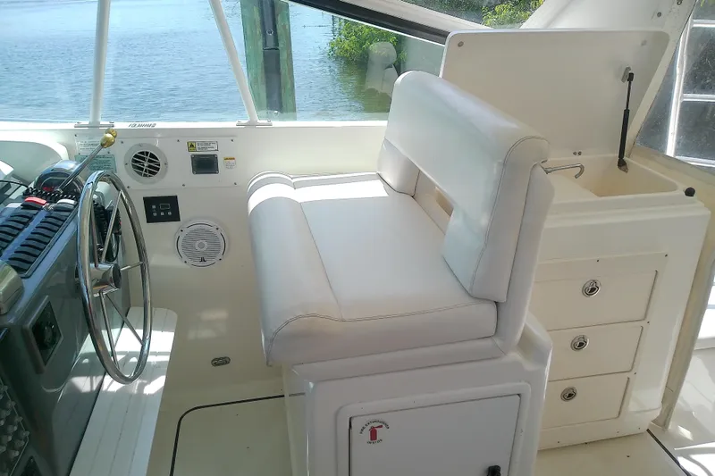 Slide: The Image of Helm of 2000 Tiara Yachts 4100 Open with white seating and steering wheel. - 33